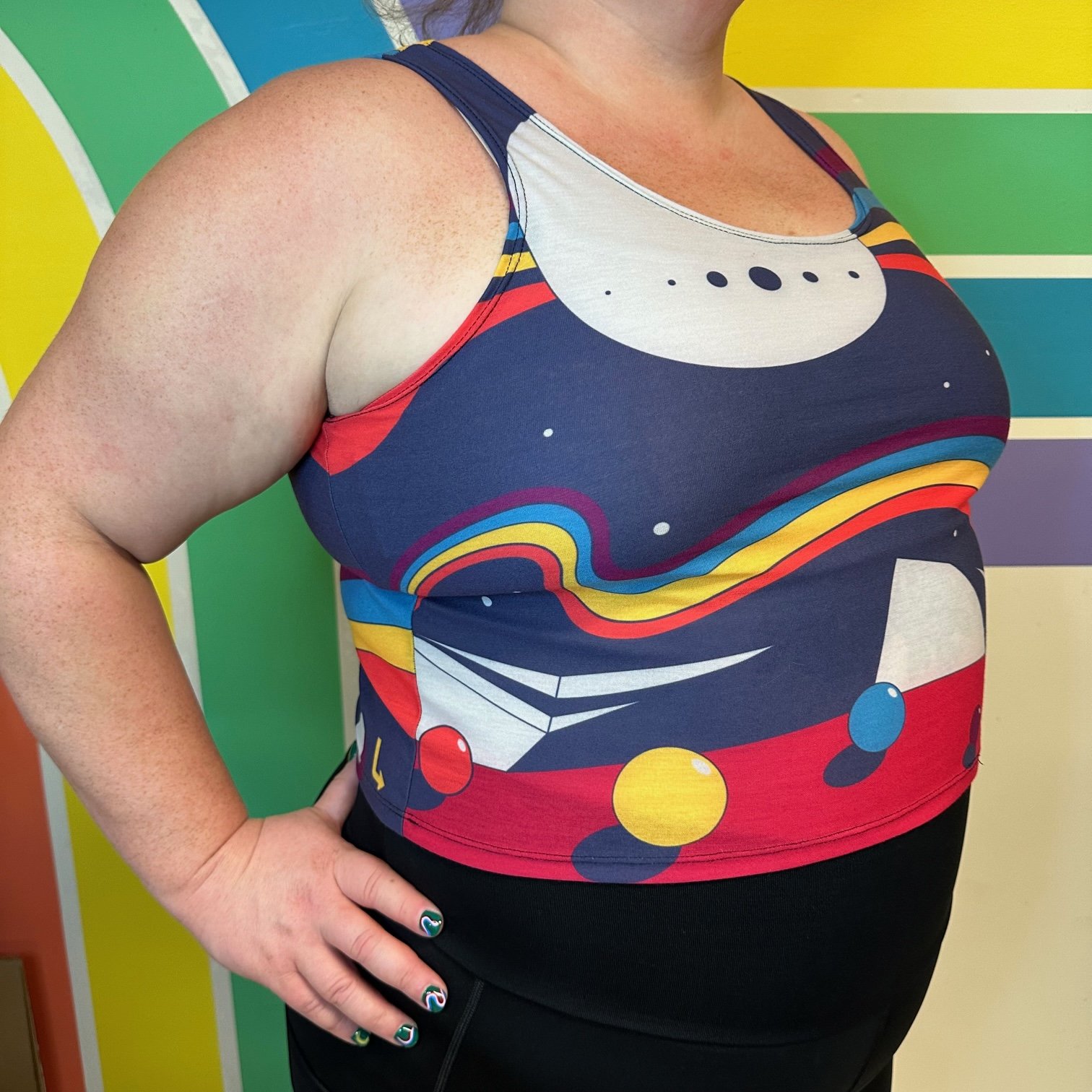 Side view of space case crop top by left turn clothing, featuring rainbows, planets and more.